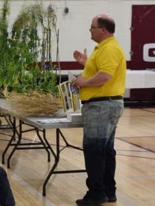 Keith Gabert uses a pair of "wet pants" to demonstrate how to test canopy conditions for sclerotinia stem rot risk.